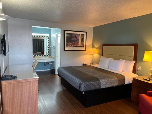 a hotel room with a bed and a bathroom at Sunset Inn in Grants Pass