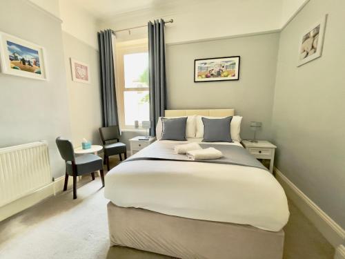 a bedroom with a large bed and a desk at The Hedley Townhouse in Bournemouth