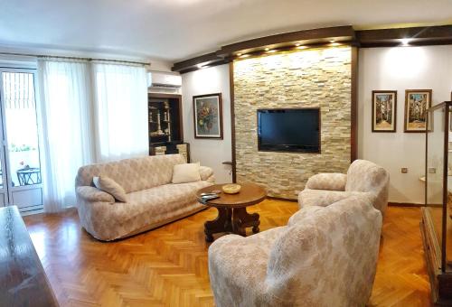 ein Wohnzimmer mit 2 Sofas und einem TV in der Unterkunft Promenade suite in Kotor