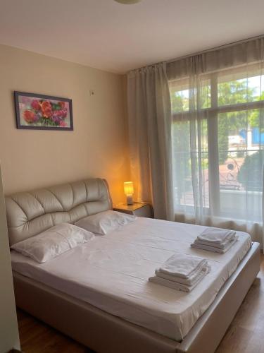 sypialnia z dużym białym łóżkiem i oknem w obiekcie Rich-3 SP apartments w Rawdzie