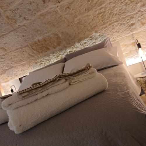 a bed with white towels and pillows on it at La Casetta in Mola di Bari