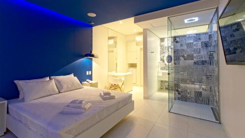 Leblon Motel في باريتوس: غرفة نوم بسرير كبير بجدار ازرق