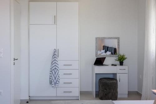 a white closet with a desk and a mirror at VILLA EKTAMA in Fiskardho