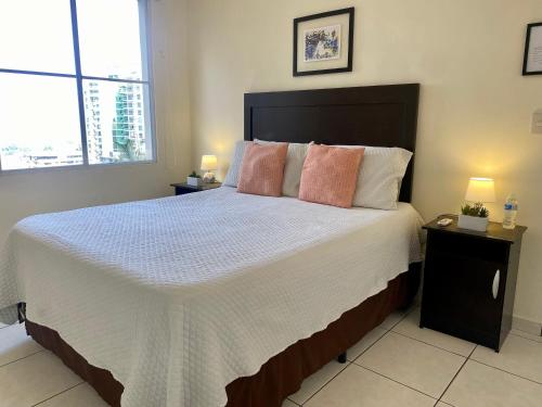 聖薩爾瓦多的住宿－Luxury Modrn Apartment, w/amazing view, 3BR,Escalon,Exclus,Secur，一间卧室配有一张大床和两盏灯。