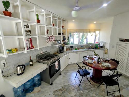 cocina con mesa y fogones horno superior en casa HIKURI en Cancún