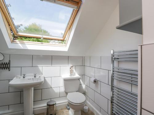 La salle de bains est pourvue d'un lavabo et d'une lucarne. dans l'établissement Parkfield Cottage, à Sturminster Marshall