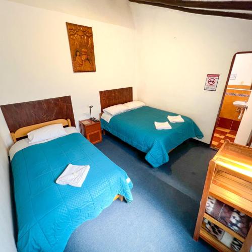 a room with two beds in a room at Hostal Teatro Inka in Cusco