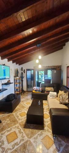 salon z kanapami, stołem i telewizorem w obiekcie Villasol - Cabaña campestre en medio de la naturaleza w mieście Rionegro