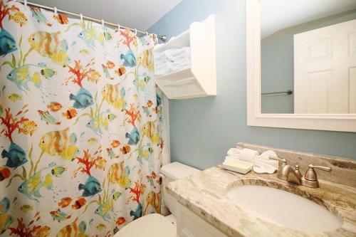 uma casa de banho com um lavatório e uma cortina de chuveiro em Tradewinds 1102 condo em Orange Beach