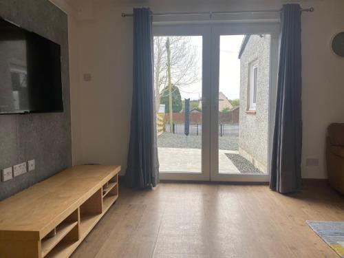 una sala de estar con una gran puerta corredera de cristal en Pure Apartments Fife - Dunfermline West, en Oakley