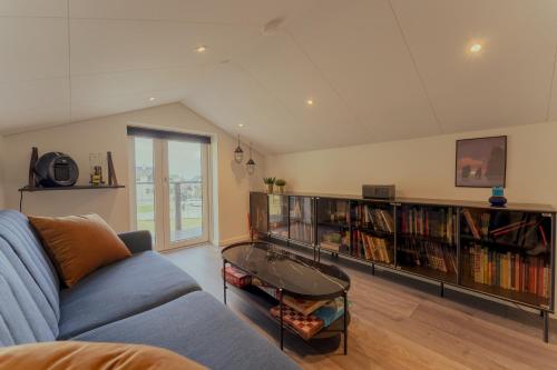 a living room with a couch and book shelves with books at Luxurious & Unique Villa / Nature / Beach / Hiking in Tjørnuvík