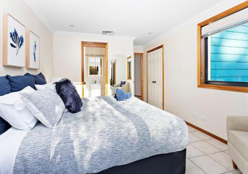 a bedroom with a bed with a dog sitting on it at Allure On Seven Mile Beach Gerroa in Gerroa