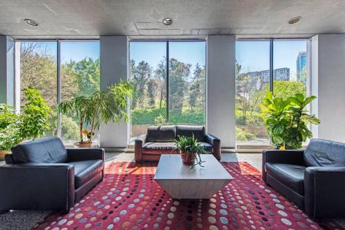 a living room with couches and a table and windows at 1109-Extra LG-King Bed-1 Free Park-Fast WiFi-DTW in Atlanta