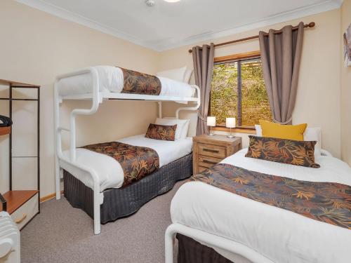 a bedroom with two bunk beds and a window at Mowamba D3 in Thredbo