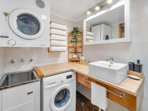 a laundry room with a sink and a washing machine at Mowamba D3 in Thredbo