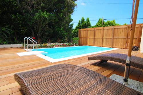 - une piscine sur une terrasse en bois avec une clôture en bois dans l'établissement Villa Piscine SESOKO -SEVEN Hotels and Resorts-, à Motobu