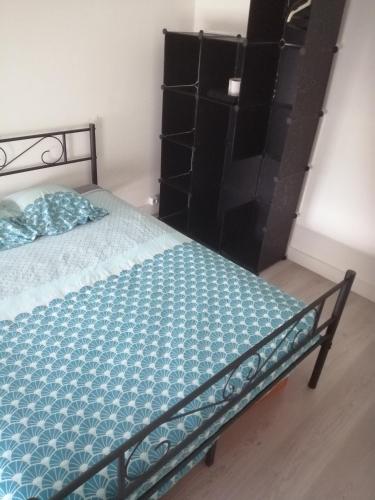 a bed in a room with black shelves at A 20 minutes de Paris in Sarcelles