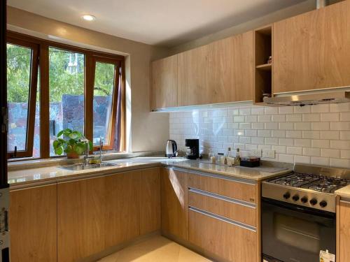 uma cozinha com armários de madeira e um forno com placa de fogão em ANTAKARANA em Lozano