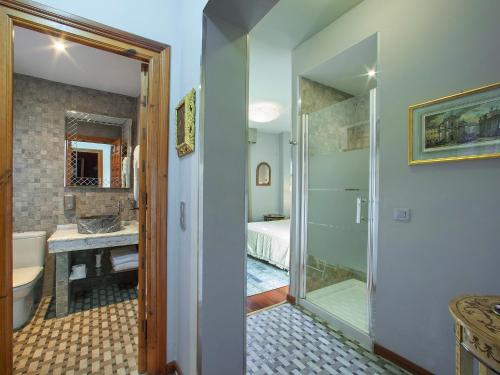 y baño con ducha, aseo y lavamanos. en Almunia de San Miguel, en Toledo