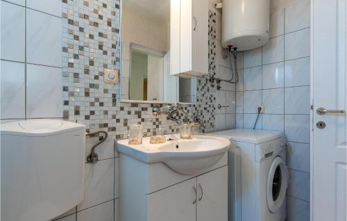 a bathroom with a sink and a washing machine at Stunning Apartment In Rogoznica With House Sea View in Rogoznica