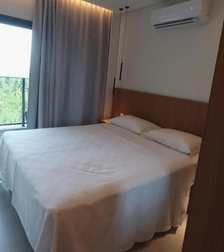 a bedroom with a large white bed with a window at Salinas Premium Resort in Salinópolis