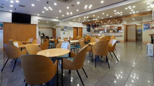 a restaurant with tables and chairs in a cafeteria at Toyoko Inn Sendai Nishi-guchi Hirose-dori in Sendai