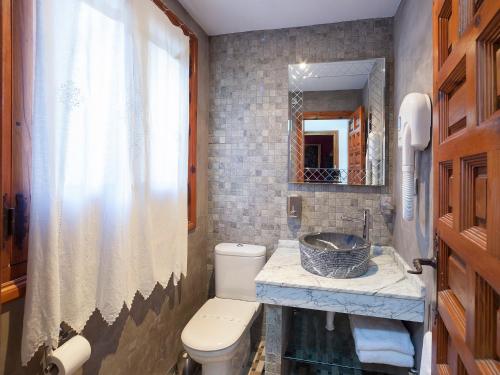 a bathroom with a sink and a toilet and a mirror at Almunia de San Miguel in Toledo