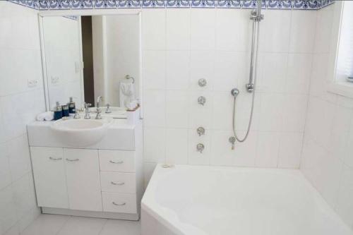 baño blanco con ducha y lavamanos en Baywatch St Helens 3 bed 2 bathrooms with views, en St Helens