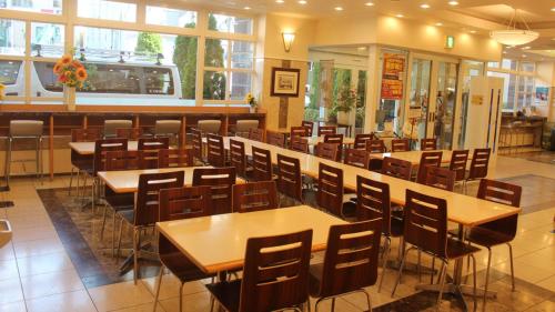 Toyoko Inn Morioka Ekimae في موريوكا: غرفة طعام مع طاولات وكراسي في مطعم