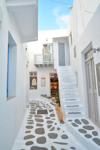 a hallway with white walls and white stairs at Oikia Suites Mykonos in Mýkonos City