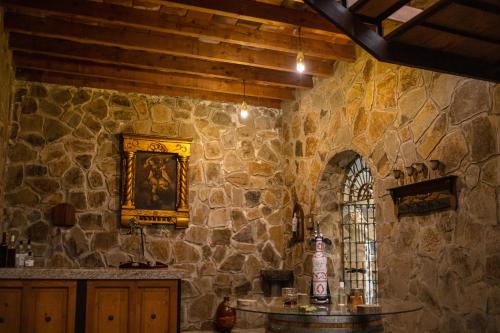 Habitación de piedra con mesa y pared de piedra. en Casa Entrevez, en Valle de Guadalupe