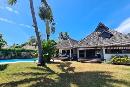 uma casa com piscina e palmeiras em Villa Naki em Maharepa