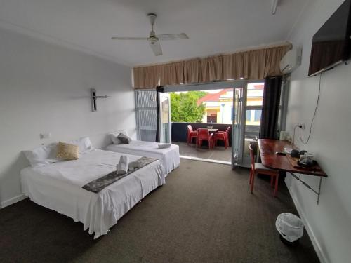 a bedroom with two beds and a table and chairs at Ayr Hotel in Ayr