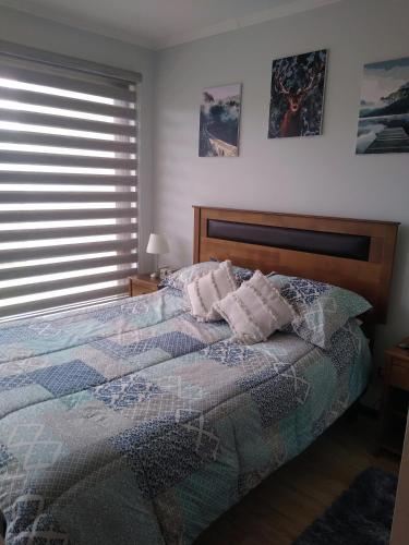a bedroom with a bed with two pillows and a window at Casa en Pingueral in Tomé