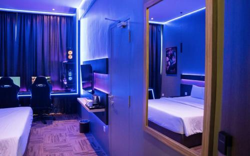 a blue room with two beds and a mirror at SEM9 Senai "Formerly Known As Perth Hotel" in Kulai