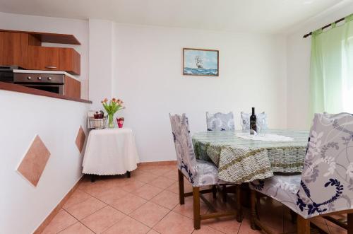 洛帕爾的住宿－Apartments and Room Sime M，厨房以及带桌椅的用餐室。