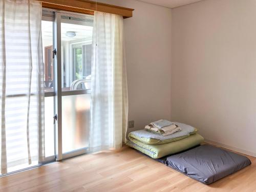 石垣島にある民宿イラヨイの窓の前にベッドが備わる部屋