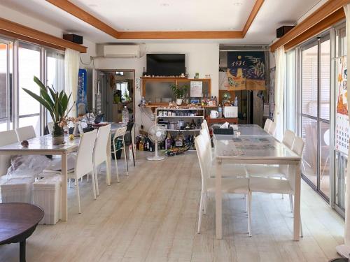 uma sala de jantar com mesas brancas e cadeiras brancas em Minshuku Irayoi em Ishigaki Island