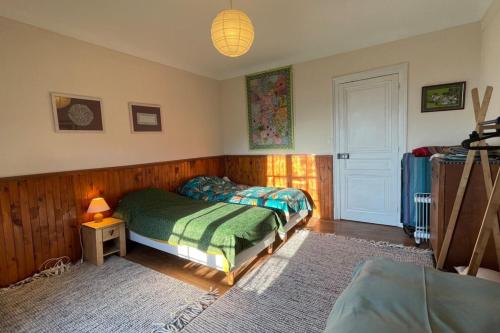 una camera con letto e tavolo con lampada di Le Mont-Joly - Appartement familial avec vue sur la montagne a Saint-Gervais-les-Bains