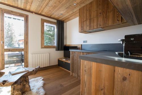 une cuisine avec des armoires en bois et un comptoir dans l'établissement Les Brigues - Appartement avec vue sur la montagne et accès aux pistes, à Courchevel