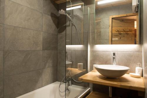 a bathroom with a sink and a glass shower at Les Brigues - Appartement avec vue sur la montagne et accès aux pistes in Courchevel