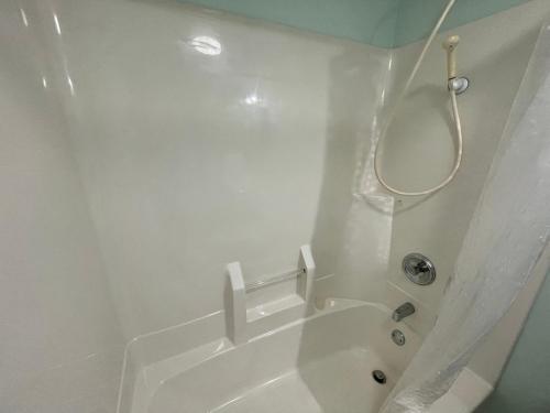 a white bathroom with a shower and a tub at HOKUTO SATOYAMA BASE in Hokuto