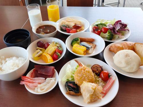 a table with plates of food on a table at Hotel Hakodate Royal Seaside BBH Hotel Group in Hakodate
