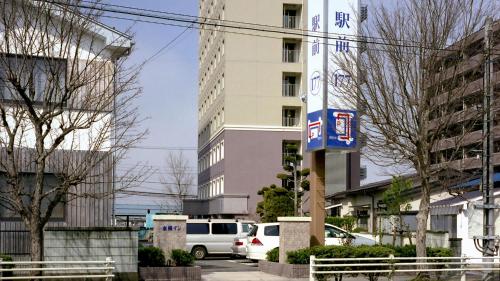 a city street with cars parked in front of a building at Toyoko Inn Aizuwakamatsu Ekimae in Aizuwakamatsu