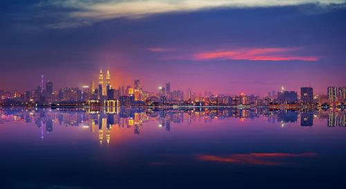 a view of a city at night from the water at Amari Kuala Lumpur in Kuala Lumpur