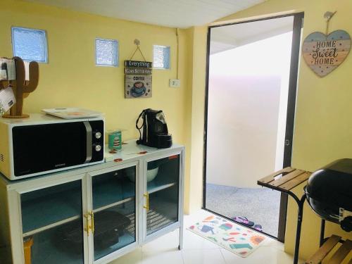 a living room with a tv and a microwave at Angelot Villa in Chaweng Noi Beach