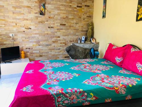 a bedroom with a bed with a colorful blanket at Angelot Villa in Chaweng Noi Beach