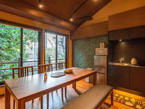 a kitchen with a wooden table and a large window at 慶有魚·松家(Kyotofish·Matsuya)*经典松树中庭*鸭川畔独栋地暖百年町屋*门前高濑川 in Kyoto