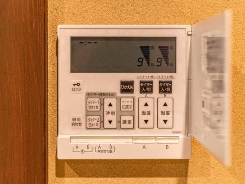 an electronic machine is attached to a wall at 慶有魚·松家(Kyotofish·Matsuya)*经典松树中庭*鸭川畔独栋地暖百年町屋*门前高濑川 in Kyoto