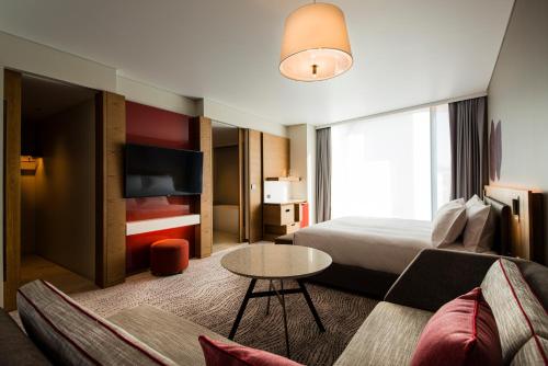 a hotel room with a bed and a couch and a table at Crowne Plaza Hobart by IHG in Hobart